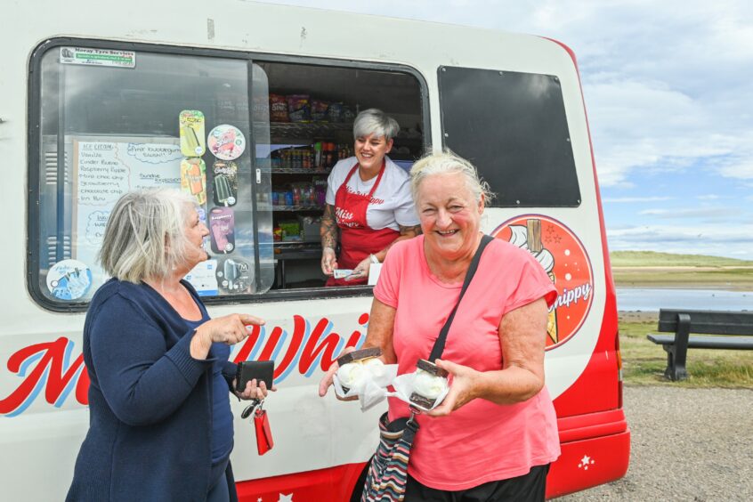 Amy smiling with customers while in her van
