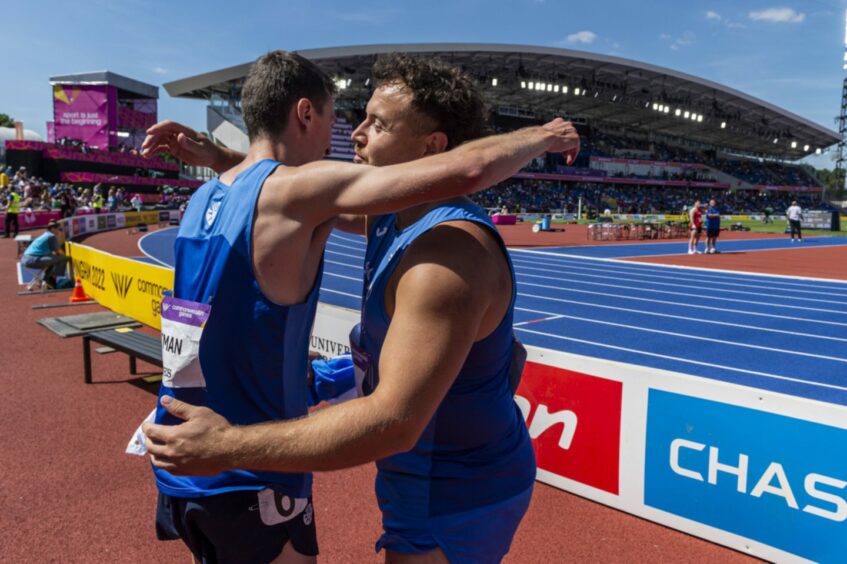 Mark Dry embraces Scotland's 1500m bronze-medalist Jake Wightman at the Commonwealth Games in Birmingham. Photo by Bobby Gavin