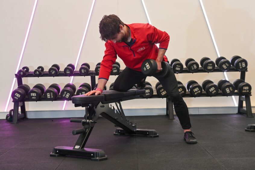 Alex Bailey shows how to do the dumbbell row exercise at Aberdeen Sports Village. 