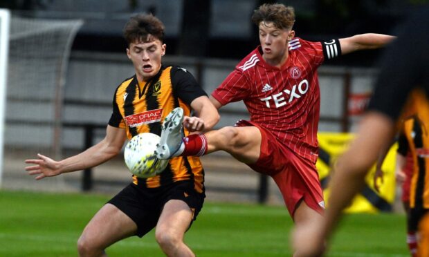 Aberdeen captain Dylan Lobban gets to the ball ahead of Huntly's Brodie Allen