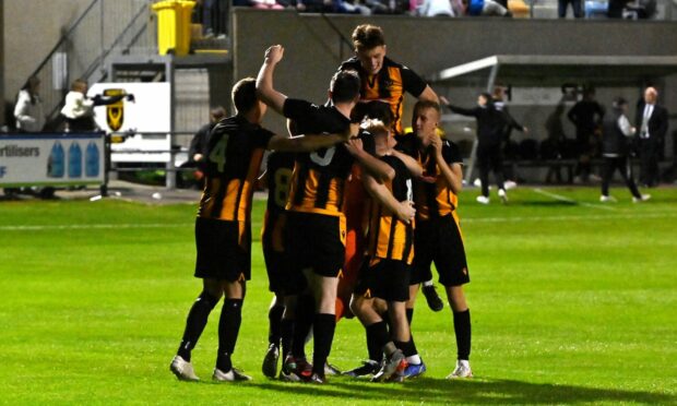 Huntly's players celebrate their penalty shoot-out victory against Aberdeen in the Evening Express Aberdeenshire Cup.