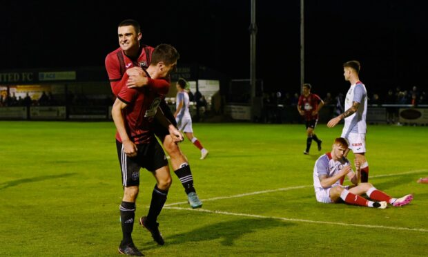 Scott Barbour jumps on the back of Fraserburgh team-mate Paul Young after Young scored their second goal against Turriff United.
