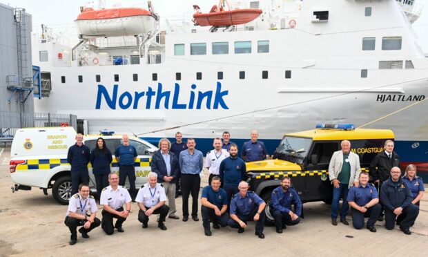 Pictured are 15 members from different teams around the north and north-east standing in front of the oldest Coastguard rescue vehicle in the fleet. Picture by Kami Thomson / DC Thomson