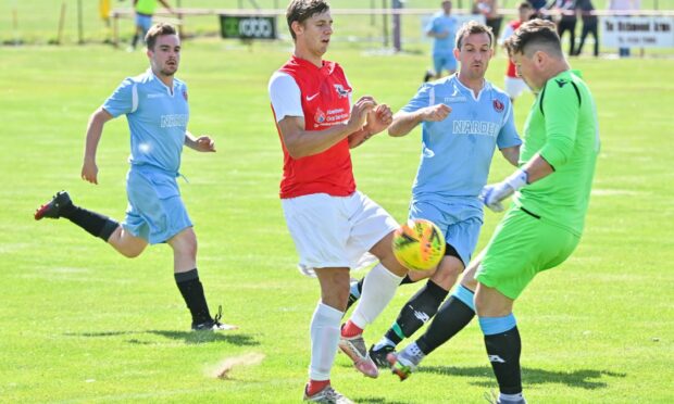 Culter's Nikolas Wozniac challenges Nairn's goalkeeper Connor Hutton. Image: Kami Thomson / DC Thomson