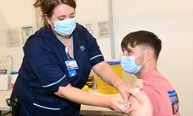 Calum Morrison receives a Covid jab from Chloe England at NHS Grampian's vaccination centre at P&J Live in September 2021. Picture by Paul Glendell