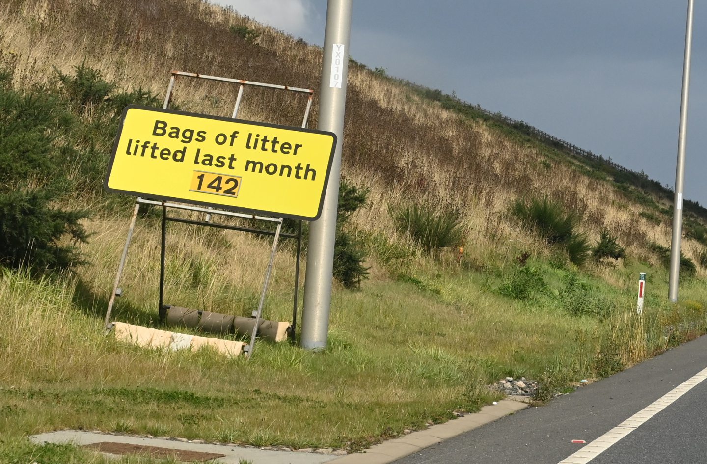 A sign on the AWPR showing 142 bags of litter were collected in July 2022.