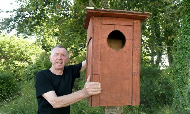 Bob Swann holding one of his bird boxes.
