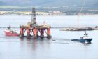 The oil rig, Ocean Vanguard, is towed from the Cromarty Firth by the tug Rota Endurance (blue) while acting as a brake is the Skandi Hera. Picture by Sandy McCook