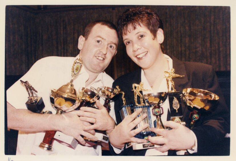 1997 - Captains of the Lord Byron pool team, John Leys and Sandra Herd, hold up the cups on offer at a prizegiving night.