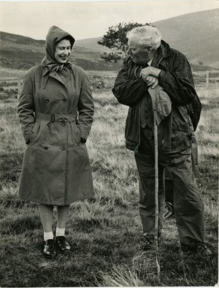 Queen Elizabeth II laughing with a gillie