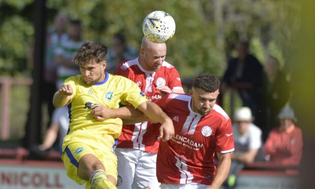 Brechin City's Euan Spark, centre, wins a header under pressure from Buckie Thistle's Sam Urquhart, left.