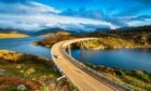 The Kylesku Bridge spanning Loch a' Chàirn Bhàin in the Scottish Highlands and a landmark on the North Coast 500 tourist driving route. Pic by Shutterstock / Helen Hotson.