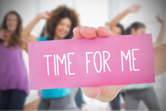 A woman holding a sign that says time for me