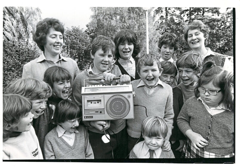 A group of Aboyne schools pupils smiling while holding a tape recorder