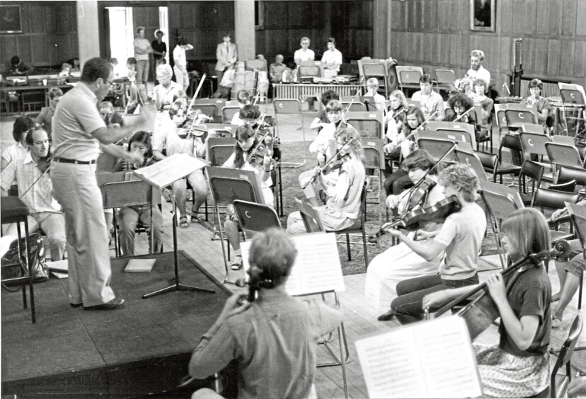 A conductor directing the festival orchestra