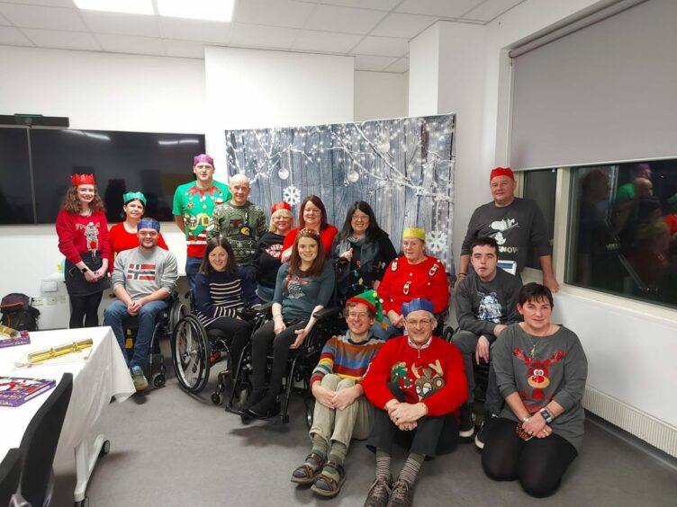 Derek, in the back row with the purple hat, celebrating Christmas with the rest of the ataxia support group.