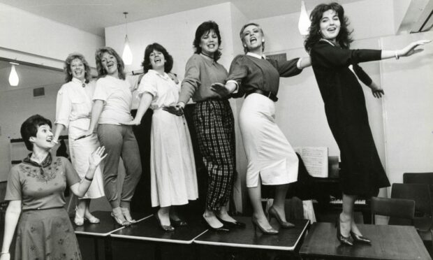 Actresses dancing on a small stage, practicing for an upcoming show