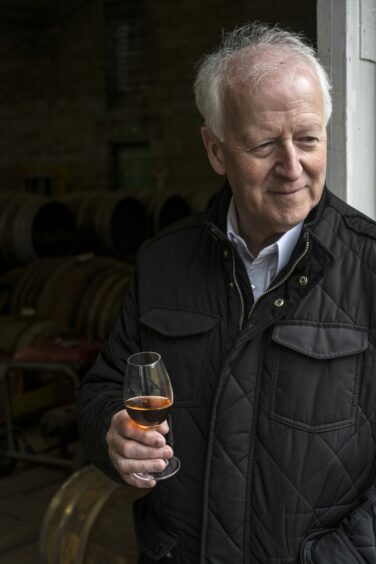 The GlenAllachie master distiller Billy Walker holding a glass of whisk.