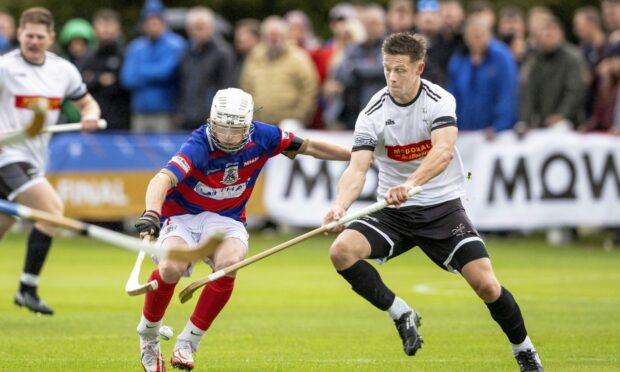 Ruaridh Anderson (Kingussie, left) competes with Craig Mainland (Lovat) during the 2022 Camanachd Cup final.