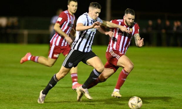 Fraserburgh's Paul Campbell, centre, tries to get away from Kieran Adams of Formartine United, right, in the Evening Express Aberdeenshire Cup