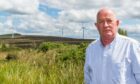 Councilor Derek Ross pictured near some turbines
