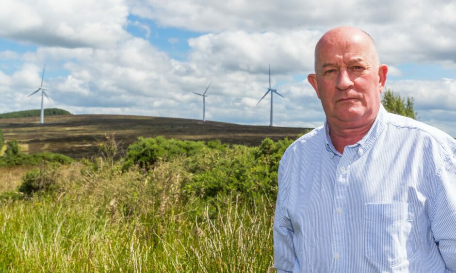 Councilor Derek Ross pictured near some turbines