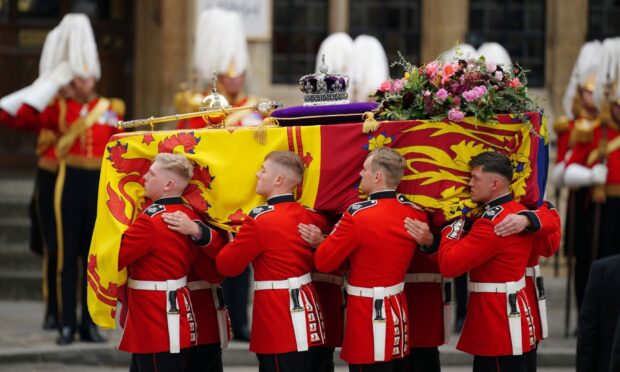The coffin of Queen Elizabeth being carried by pallbearers at Westminster Abbey. Picture by Peter Byrne/PA Wire.
