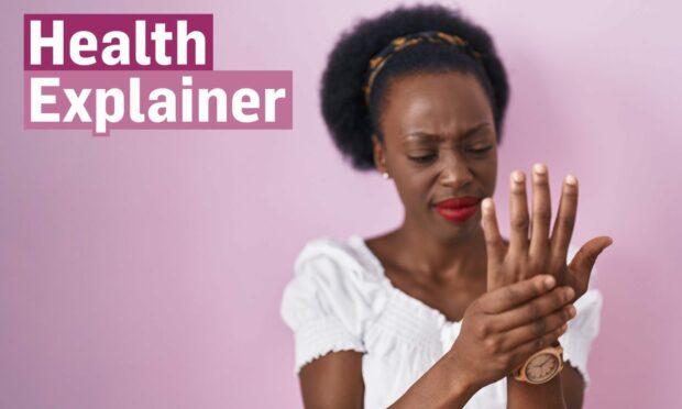 Woman with rheumatoid arthritis holding her hand/wrist in pain