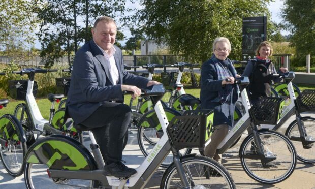The firm providing 54 e-bikes at six sites including Inverness Railway Station in deal worth £388k is in legal talks with contractor Hitrans.  Picture shows MP Drew Hendry at the 2021 launch of Hi-Bike with Councillor Trish Robertson and Vikki Trelfer of Hitrans. Image: Hitrans