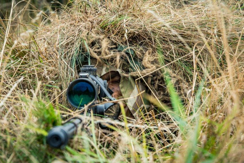 A sniper with his 338 Rifle uncover.