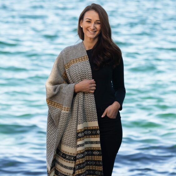 Model poses with Joan Fraser shawl by sea.