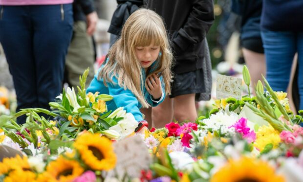 Countless flowers have been placed at the gates of Balmoral during the day. Photo: Kath Flannery/DC Thomson