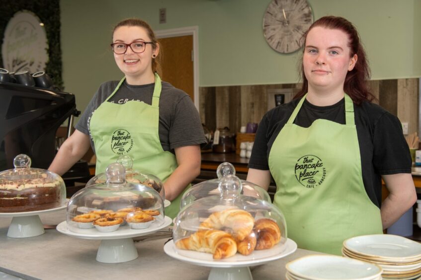 Two members of staff wearing aprons