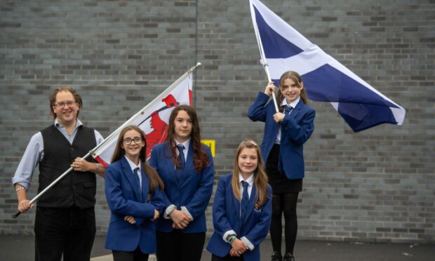 Philip Tibbetts, the Lyon Court Vexillologist for Scotland, visited Inverurie Academy as a competition to find a new Aberdeenshire flag is launched. Pupil Isla Bateman waves the Saltire with, from left, Shannon Jamieson, Iona Duncan and Neve Simpson.   Picture by Kami Thomson
