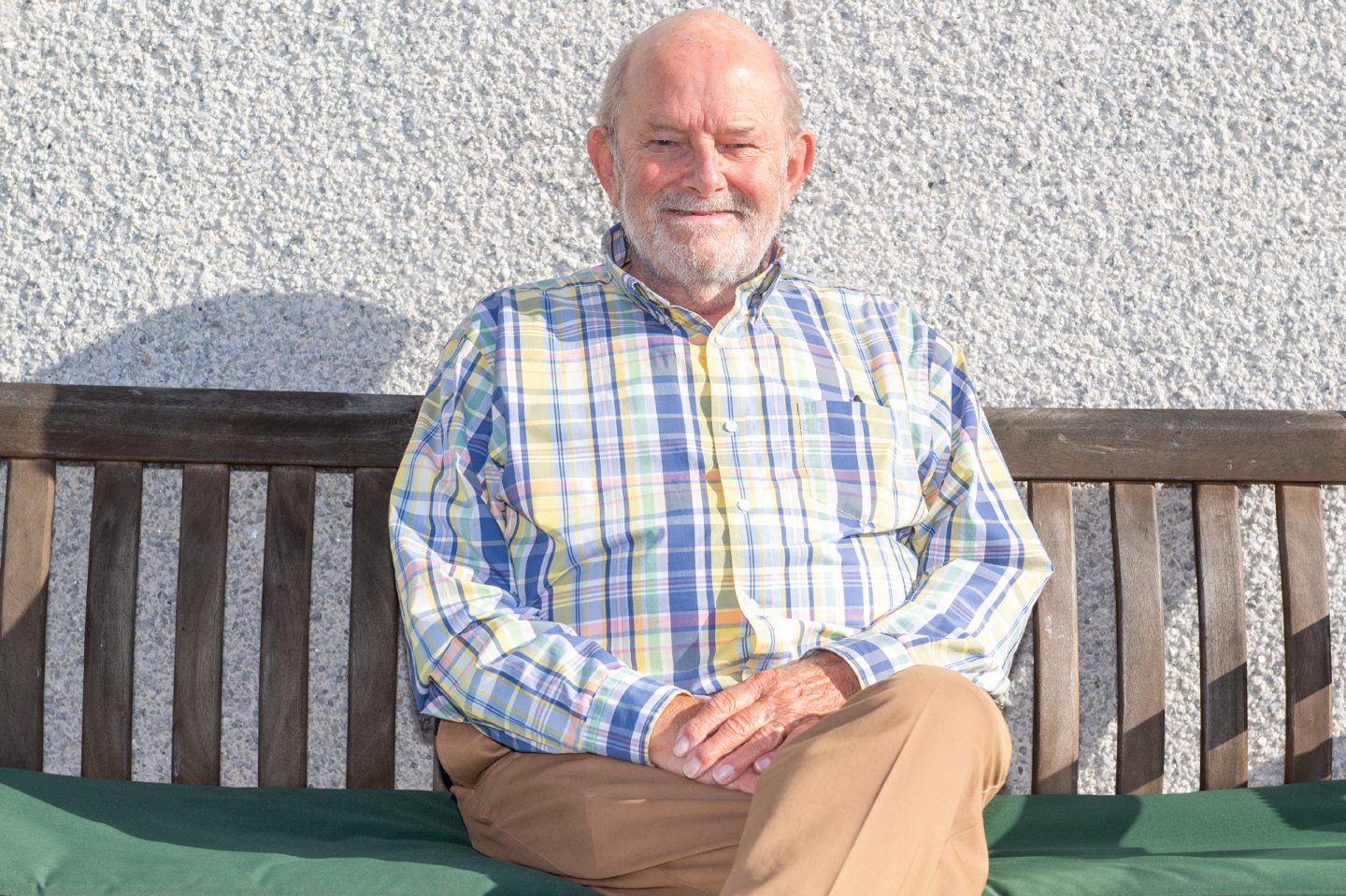 Geoff sitting on a bench in his garden. He's spoken about impact of osteoporosis on men