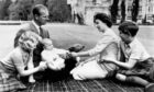 Seated comfortably on a tartan rug, members of the Royal family play with Prince Andrew in the grounds of Balmoral. Picture by PA, 1960.