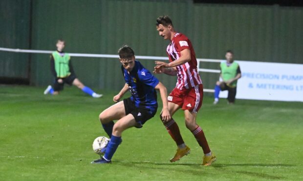 Formartine United's Aaron Norris, right, tries to win possession from Lyall Booth of Huntly