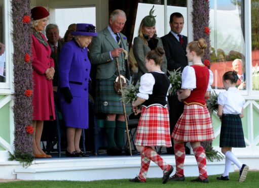 The Queen, Camilla Queen Consort, King Charles III and Mrs Autumn Phillips receive flowers from local dancers Amelia Fraser, Kaitlin Frew, Eilidh Murdoch at the 2019 Braemar Gathering. Picture by Kenny Elrick