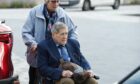 Bill MacDowell being pushed into court in a wheelchair by wife Rosemary