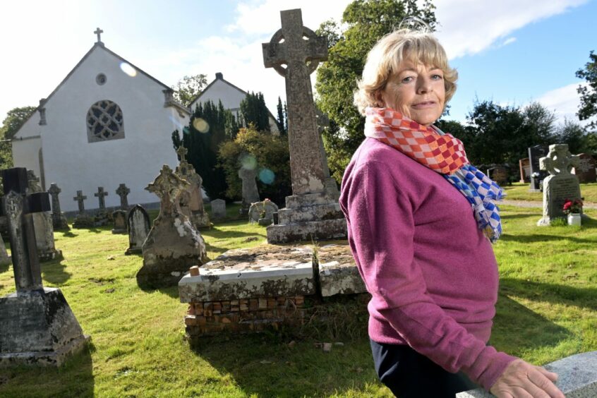 Flora Fraser standing surrounded by graves