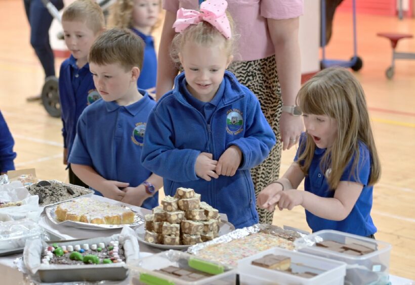 Ness Castle Primary Pupils admiring the showstoppers, traybakes and individual cakes that their classmates entered into the Great Ness Castle Bake Off. Picture by Sandy McCook