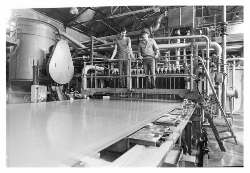 1986: Drierman Ashley Watt and, right, machine assistant Michael Gray keep an eye on the quality of the paper from the 'wet end' on the machine." Image: DC Thomson archives.