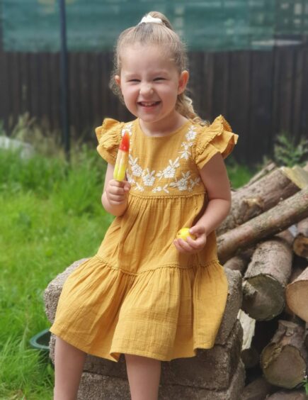 Sophie who has coeliac disease laughing and enjoying an ice cream in the garden