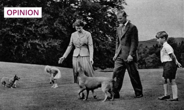 The Queen and her family walk the grounds of Balmoral with two of her dogs