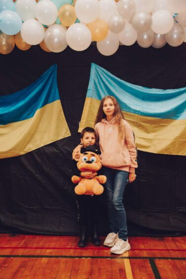 Proudly standing by their country's flag, two of the children attending the Ukrainian school.