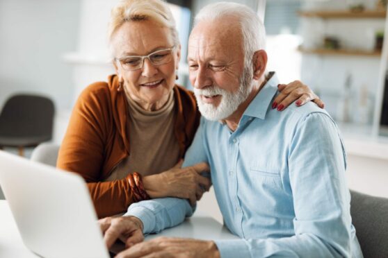 soon-to-be pensioners look at laptop