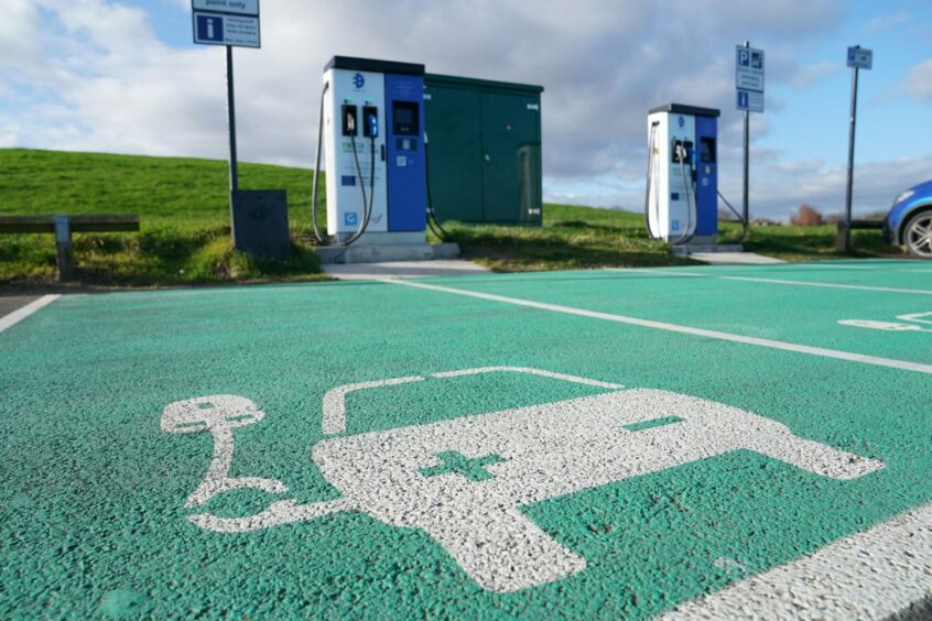Electric vehicle charger with image of plug-in on ground.