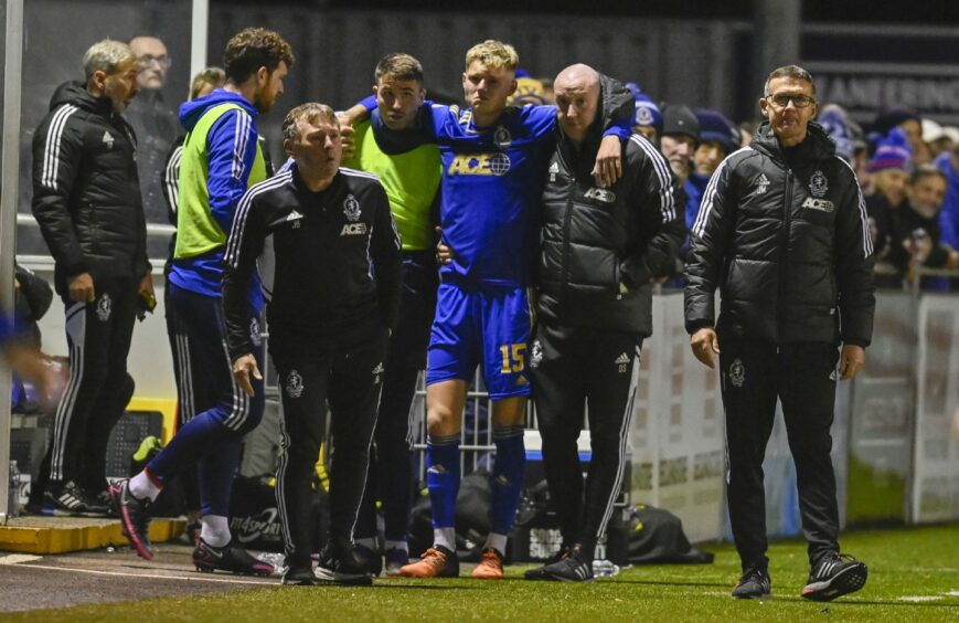 Cove Rangers defender Kyle McClelland is helped off against Dundee. Image: SNS