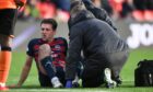 Ben Purrington receives treatment in Ross County's match against Dundee United. Image: SNS