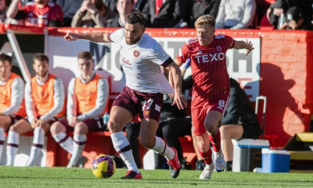 Connor Barron in hot pursuit of Hearts midfielder Robert Snodgrass at Pittodrie. Image: SNS Group